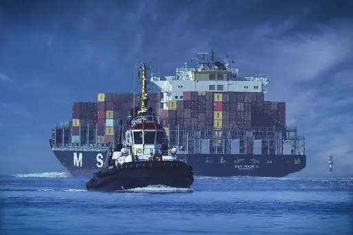 a large boat is in the water with a large building