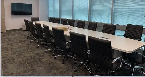A room with a large white table and a large window