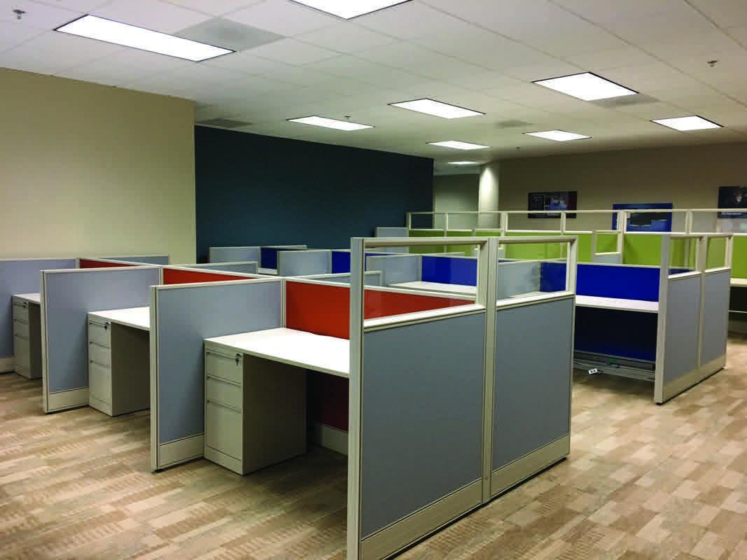 A room with a row of tables and a wall of desks