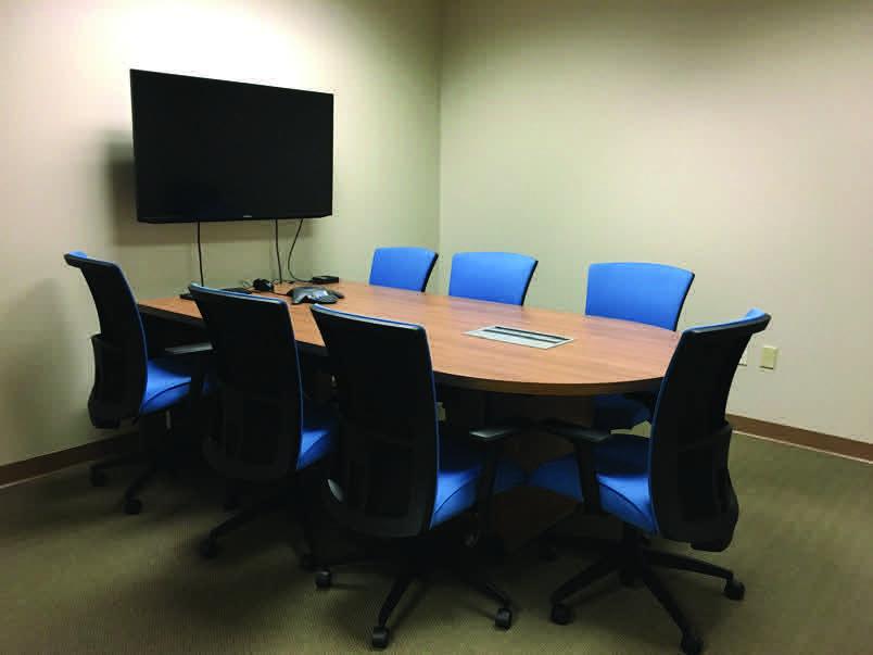 A room with a table and a large screen tv