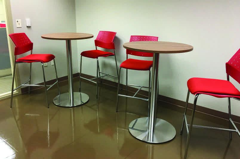 A row of tables with chairs and a red table cloth