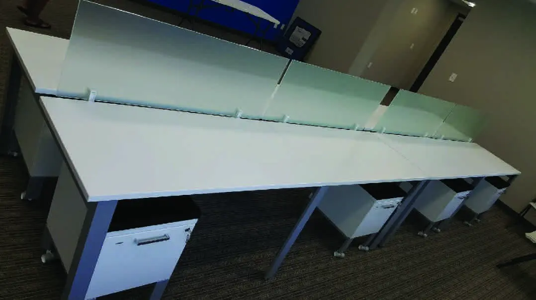 A row of white tables with a blue wall